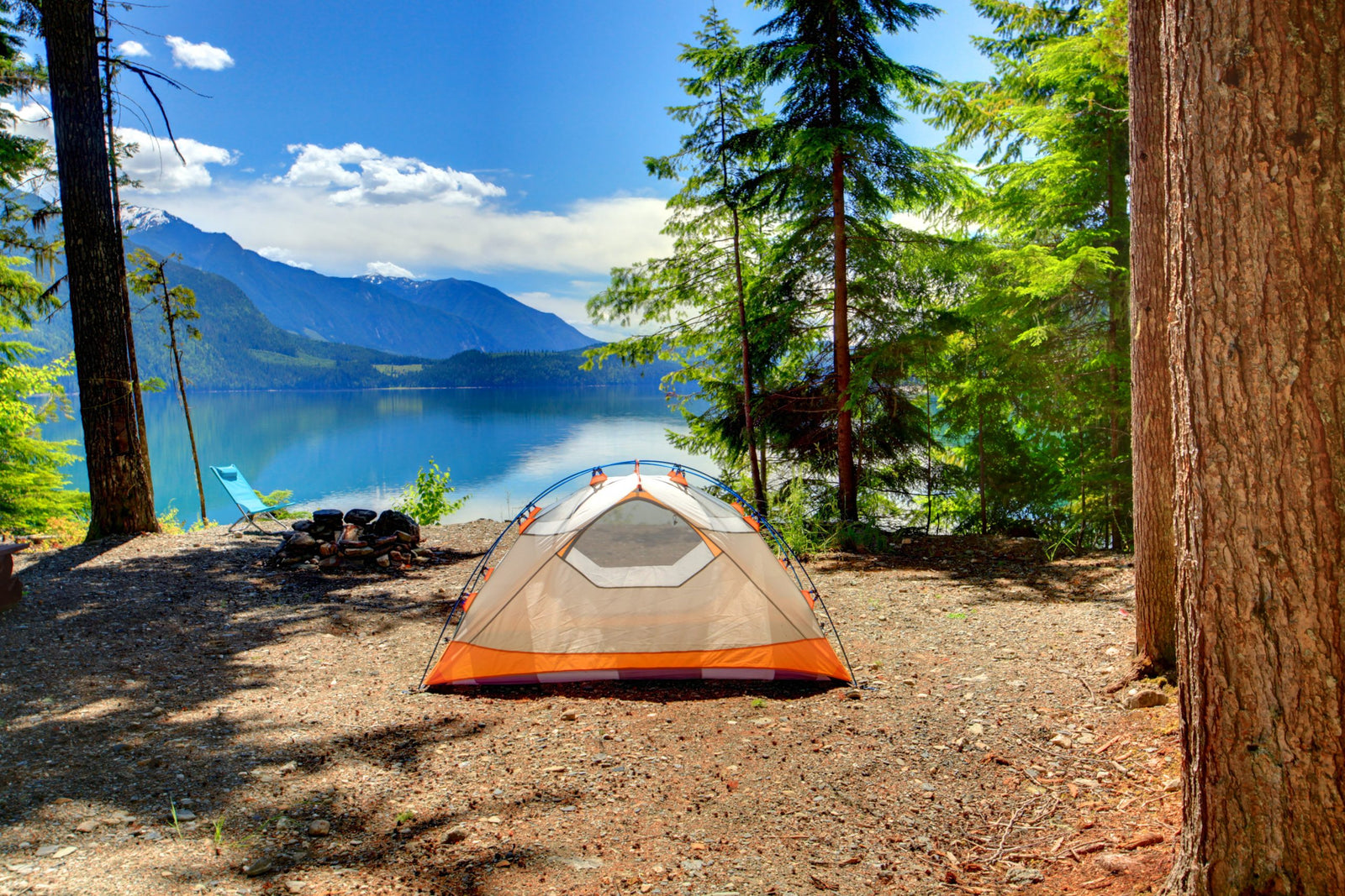 Camping tent located beside a lake and forest with campers using biodegradable soap and shampoo