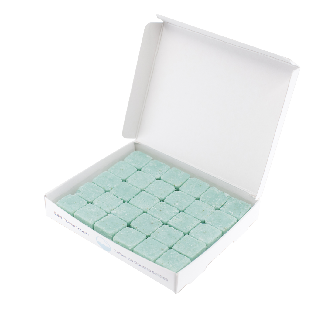 30 waterless, biodegradable, natural, dissolvable body wash tablets in cube form in an open recyclable box. The tablets are blue and the box is white.